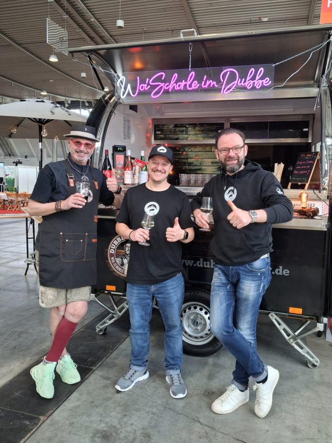 Frank mit seinen Gästen Gästen genießen das Wein-Schorle